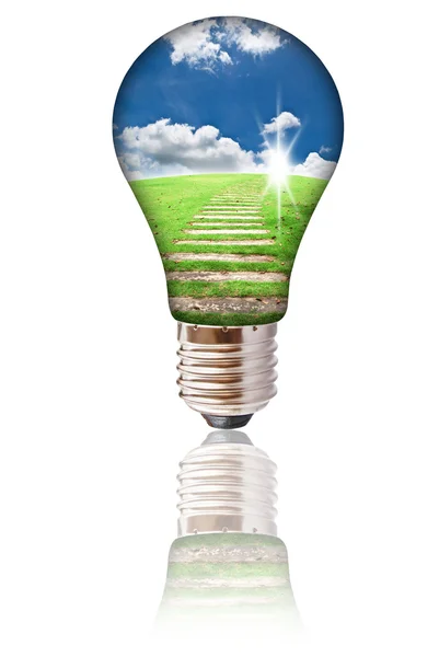 Light bulb with blue sky and grass field isolated. — Stock Photo, Image