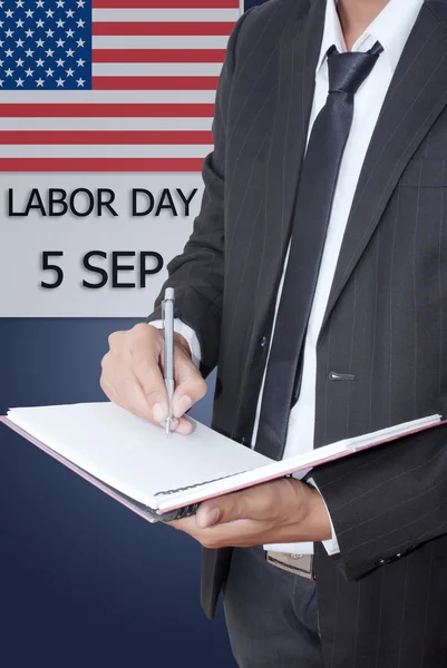 Asian businessman writing on notebook on labor day. — Stock Photo, Image