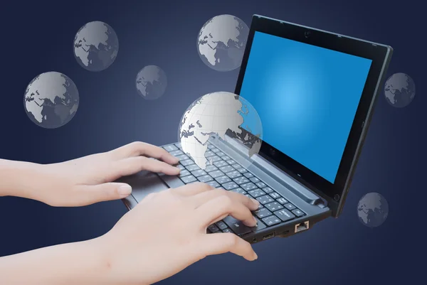 Рука натискає клавіатуру ноутбука з глобусом — стокове фото