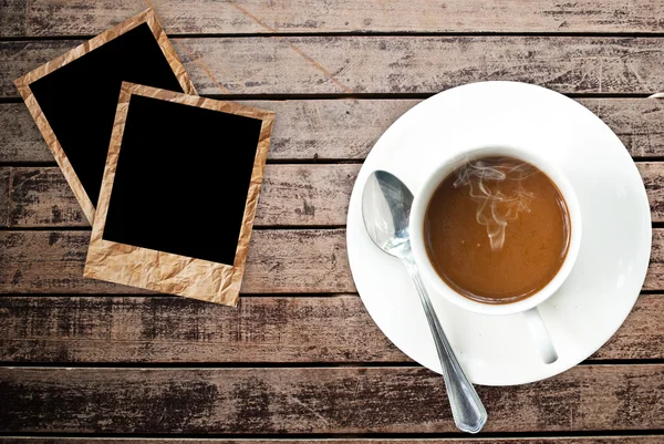 Coffee cup on the wood texture with photo frame — Stock Photo, Image