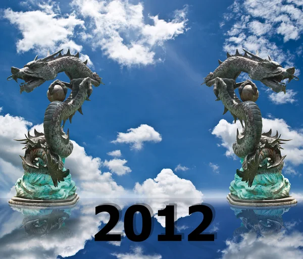 Standbeeld van de draak met de blauwe hemel veld voor nieuwe jaar 2012 — Stockfoto