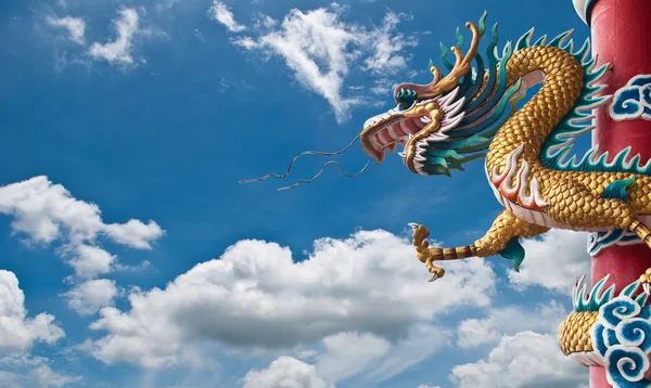 Standbeeld van de draak met de blauwe hemel veld. — Stockfoto