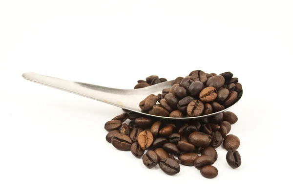 Cuillère mettant les grains de café isolés sur le blanc . — Photo
