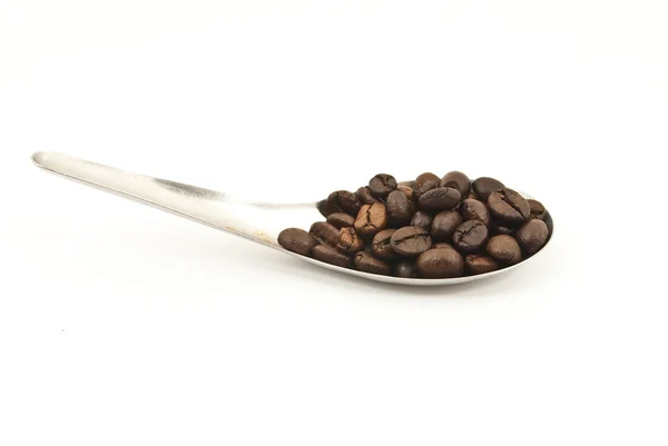 Spoon putting the coffee beans isolated on the white. — Stock Photo, Image