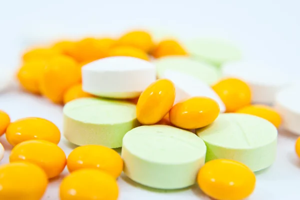 Muchos medicamentos amarillos y blancos se aíslan en el blanco . — Foto de Stock