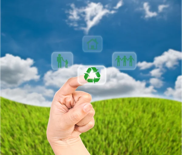 Mano presionando icono de reciclaje en el campo de hierba . — Foto de Stock
