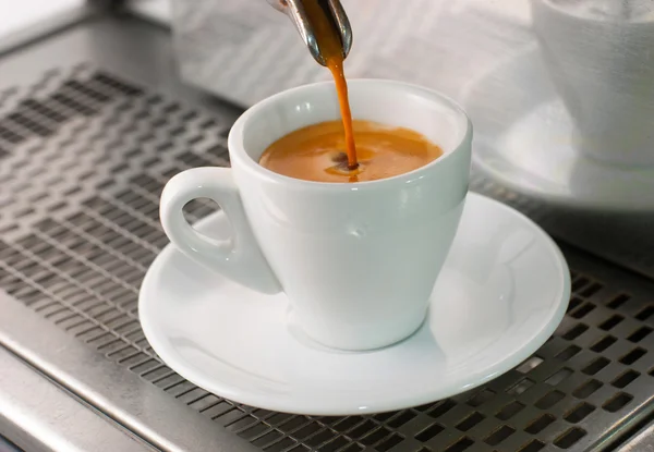 Espresso pours out of a group head into a coffee shot glass. — Stockfoto