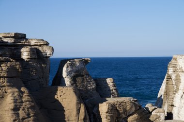 Conical rocks against the ocean clipart