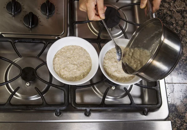 Pouring Oatmeal into Breakfast Bowls — Stock Photo, Image