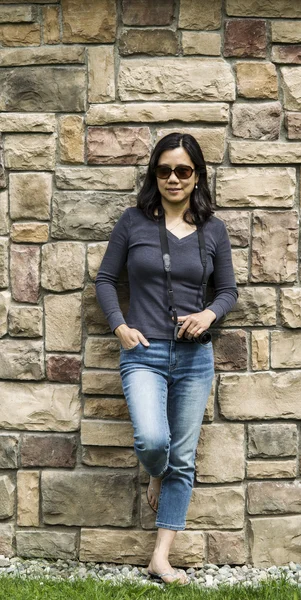 石の壁に対して休んでアジア女性 — ストック写真
