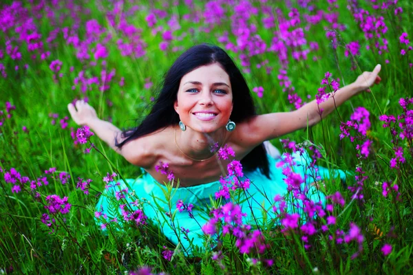 Женщина на летнем цветочном поле — стоковое фото