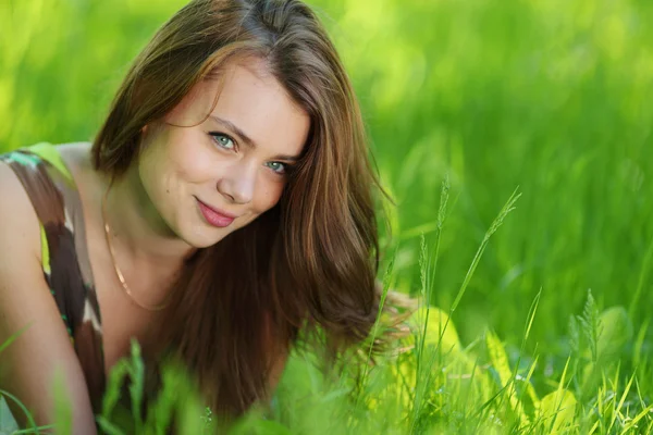 Mooie vrouw opleggen van gras — Stockfoto
