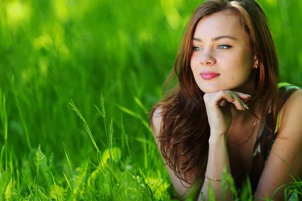 Schöne Frau, die auf Gras liegt — Stockfoto