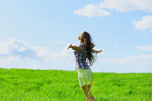 Жінка на літньому зеленому полі відчуває свободу — стокове фото