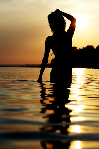Silhouette di una donna in spiaggia — Foto Stock