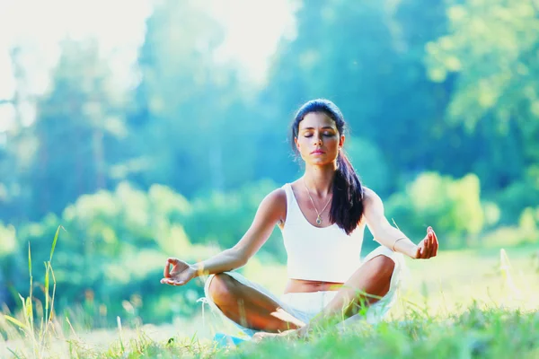 Yeşil Park 'ta yoga yapan genç bir kadın. — Stok fotoğraf