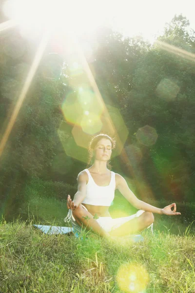 Junge Frau macht Yoga-Übungen im grünen Park — Stockfoto