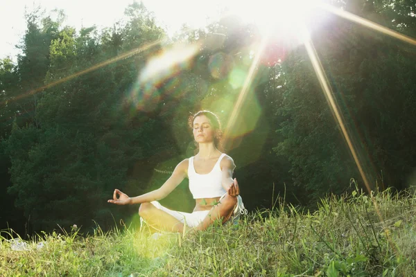 Ung kvinne som gjør yogaøvelser i grønn park – stockfoto
