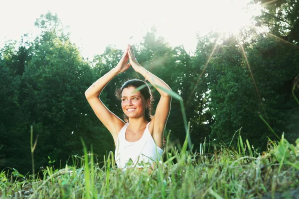 Mujer joven haciendo ejercicio de yoga en el parque verde —  Fotos de Stock