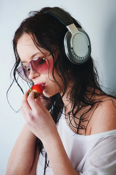 Vrouw in telefoons eten aardbei — Stockfoto