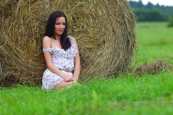 Девушка рядом с стогом сена — стоковое фото
