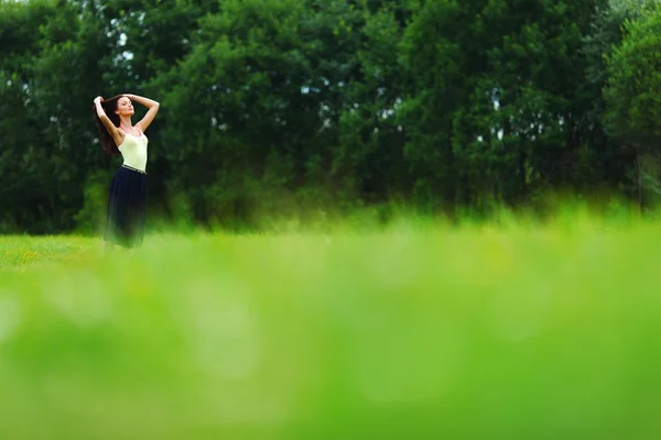 Жінка на зеленому трав'яному полі — стокове фото