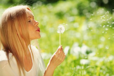 Girl blowing on a dandelion clipart