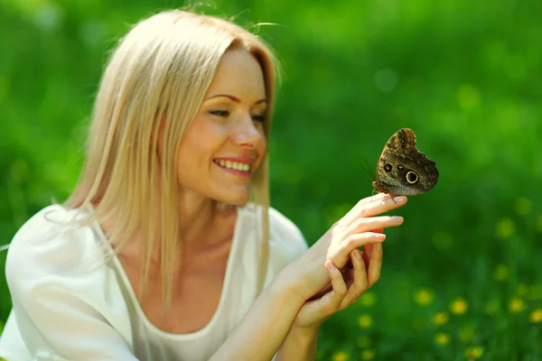 Kvinna leker med en fjäril — Stockfoto