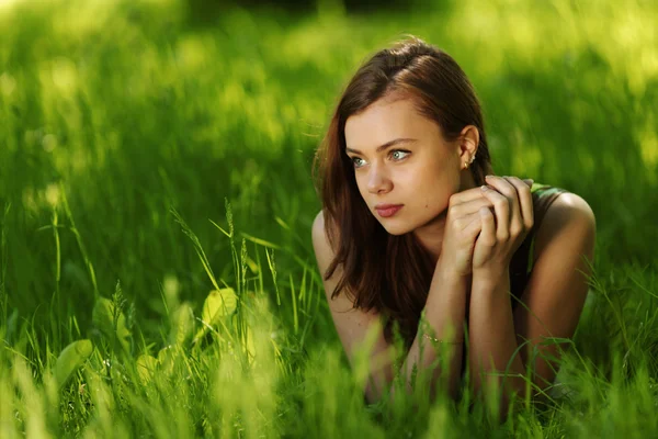 緑の芝生の上に横たわるブルネット — ストック写真