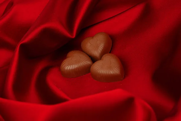 Candy srdce na červené saténové — Stock fotografie