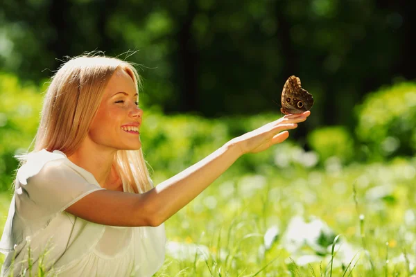 Femme jouant avec un papillon — Photo