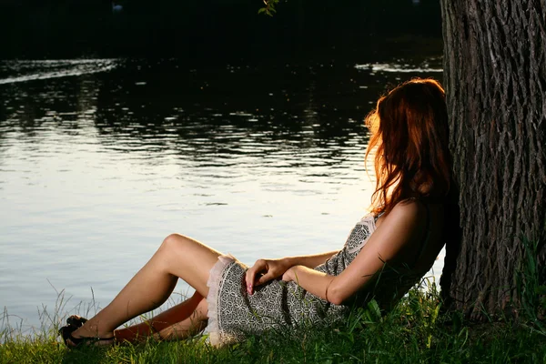 Dívka sedící na břehu řeky tha — Stock fotografie