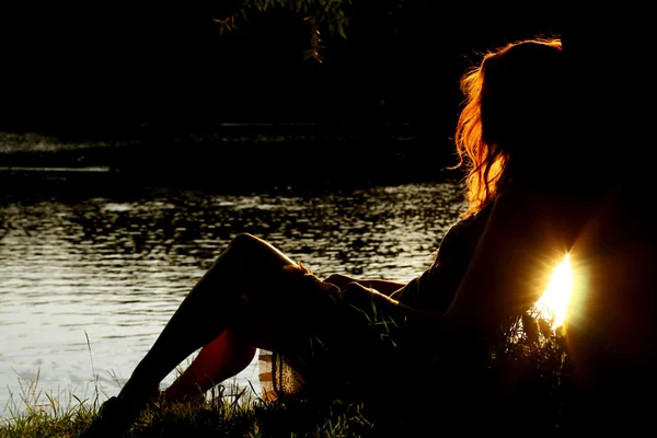 Flicka sitter på tha floden — Stockfoto
