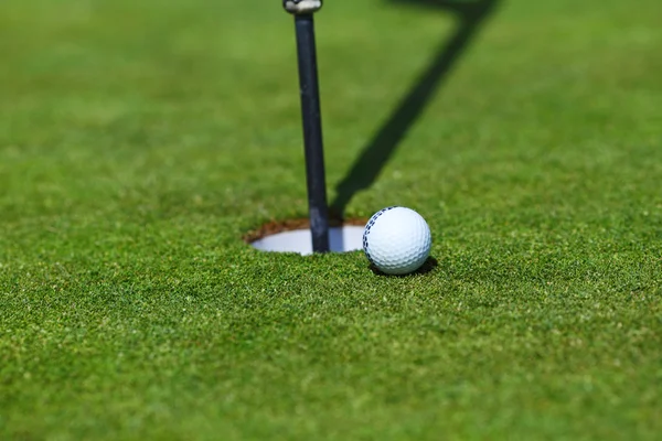 Pelota de golf en el labio de la taza — Foto de Stock
