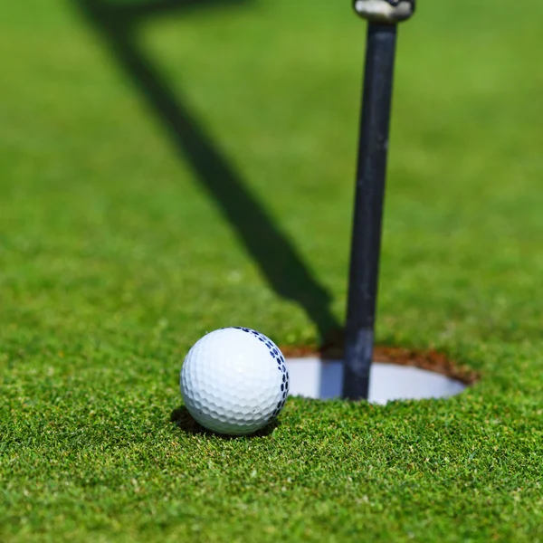 М'яч для гольфу на губі чашки — стокове фото