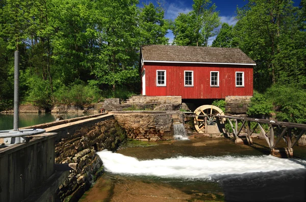 Historisches Gebäude des alten Wassersägewerks und kleiner Staudamm. Stockbild
