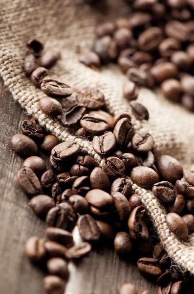 Grãos de café e tecido de serapilheira — Fotografia de Stock