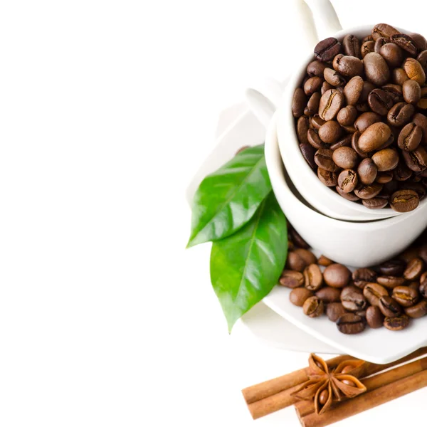 Kávová zrna v bílých cup izolovaných na bílém pozadí — Stock fotografie