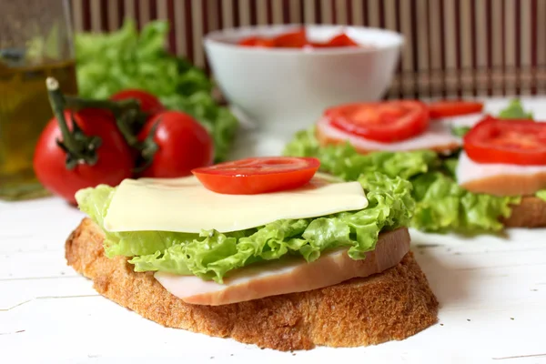 Sandwich with tomato, cheese, bacon and salad — Stock Photo, Image