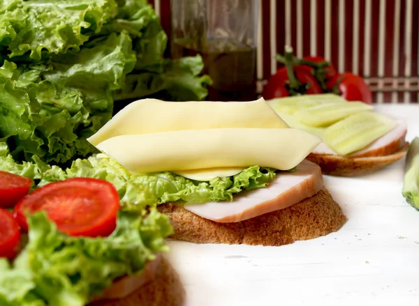 Smörgåsar med ost skivor, tomat, bacon och sallad — Stockfoto