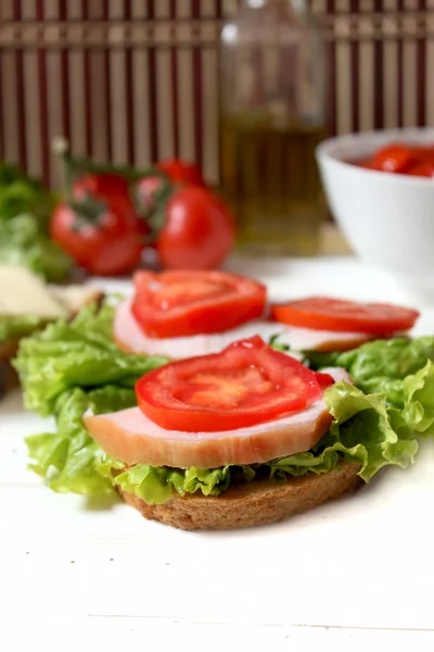 Tasty sandwich with bacon, tomato and salad — Stock Photo, Image