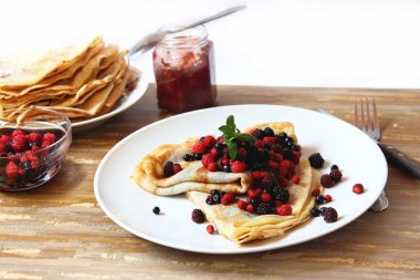 Pancakes with fresh berries , jam and mint clipart