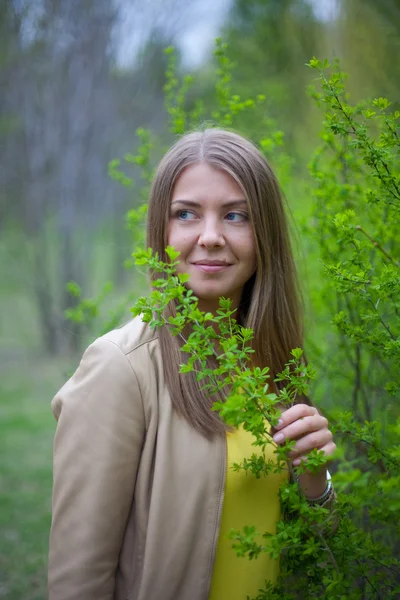 Retrato de uma menina com arbusto verde — Fotografia de Stock