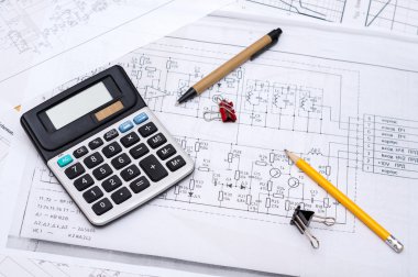 Electrical drawings with calculator, pencils and paper clips clipart