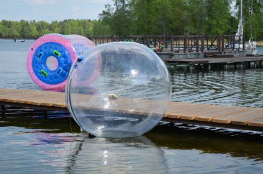 Zorbing air bubbles on water. Pier lake Trakai clipart