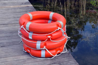 Life savers buoys orange stack wooden lake pier clipart