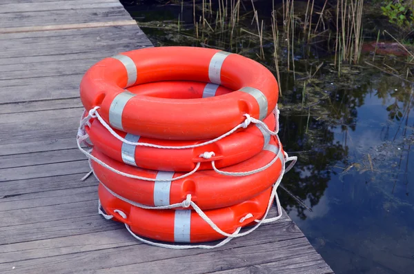 Life savers buoys orange stack wooden lake pier — Stock Photo, Image