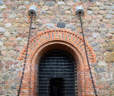 Entrance to hall of castle gates hang on chains clipart