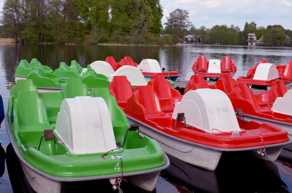 Bicicletas de agua verde y rojo bloqueado en el muelle del lago —  Fotos de Stock