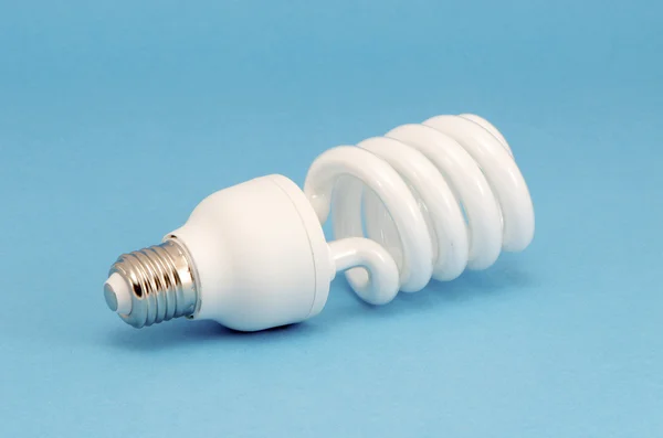 Novel fluorescent light bulb on blue background — Stock Photo, Image